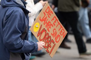Ein Demonstrant hält ein Schild in der Hand, Aufschrift: „Die fetten Jahre sind vorbei"